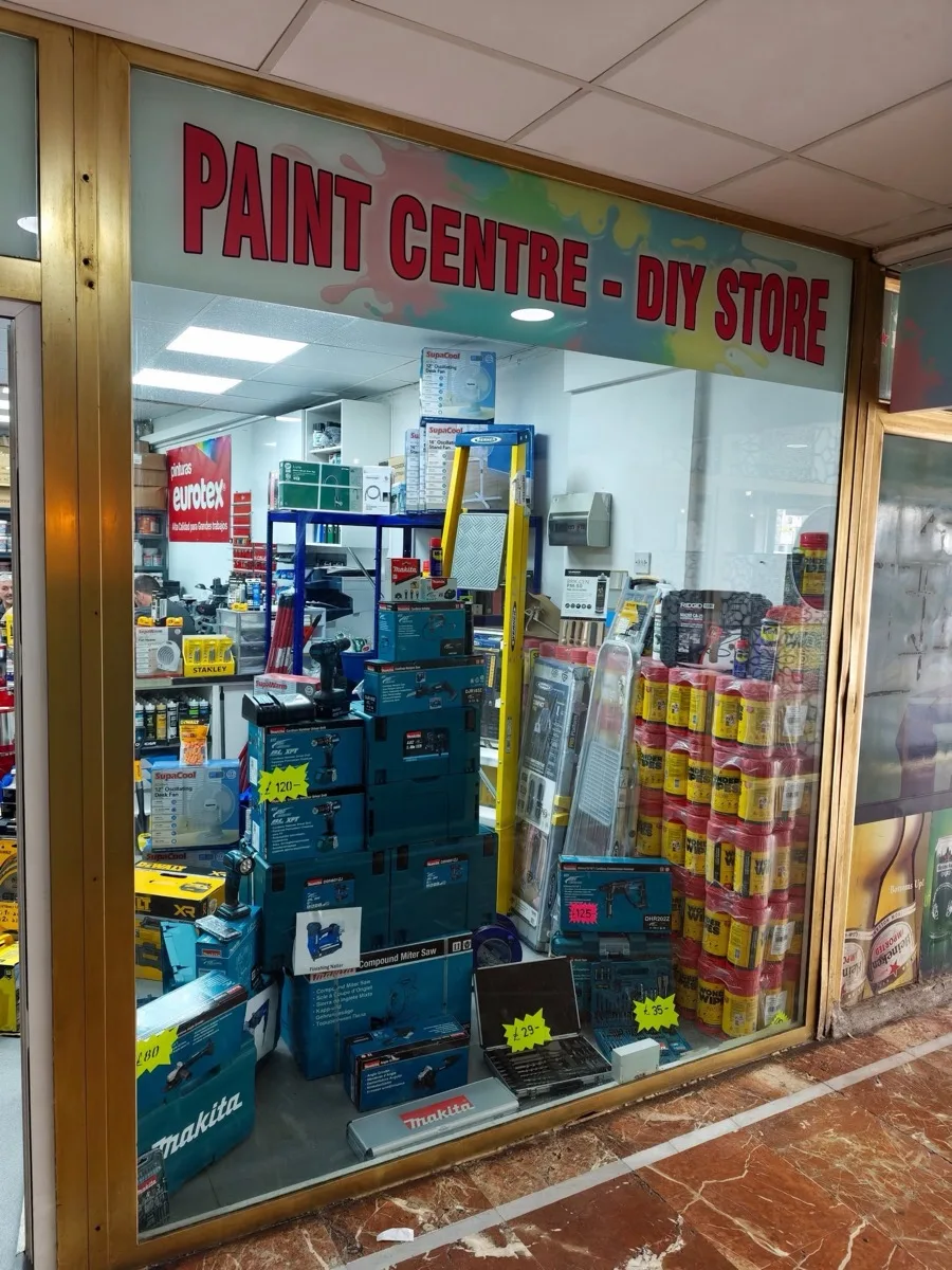 Looking into the shop window: the Eurotex paint sign, a Stanley display, stacked Makita cases and towers of Wonder Wipes.